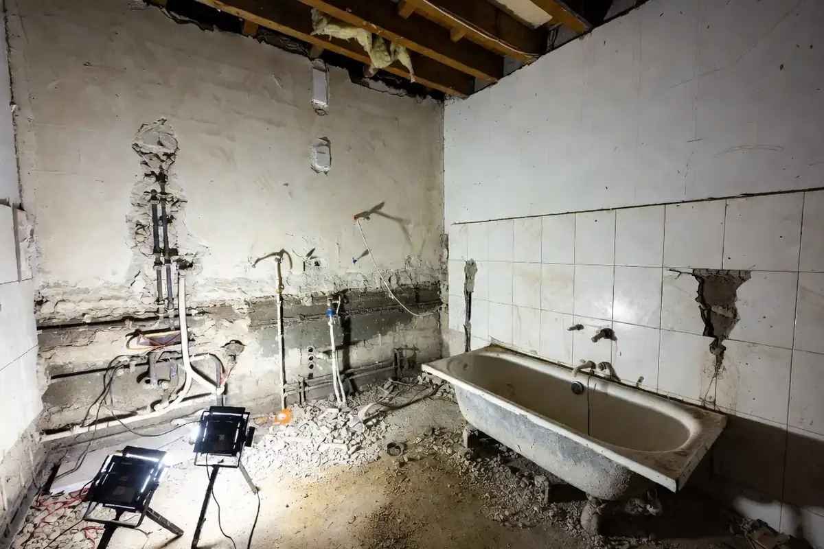 Salle de bains en cours de démolition, réseaux à nu (visuel d’illustration)
