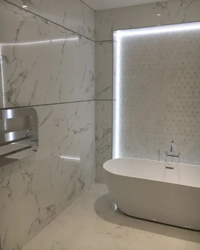 Salle de bains en marbre avec baignoire îlot, réalisée par RG Plomberie